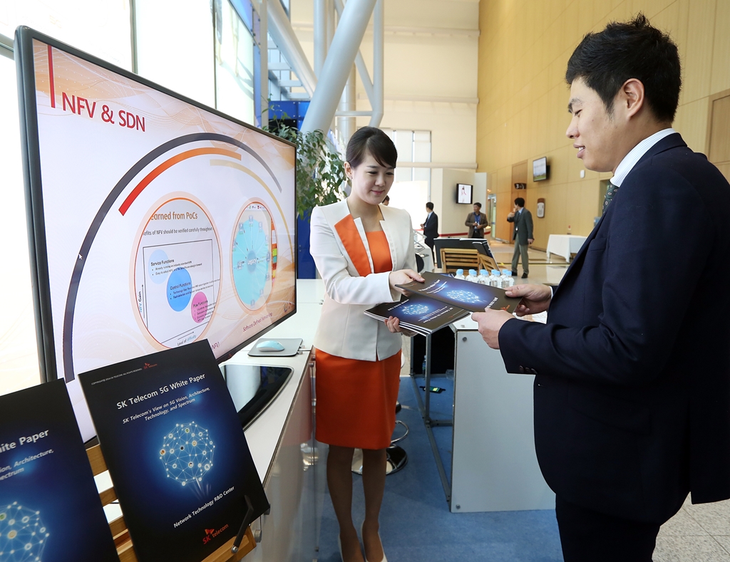 A employee of SK Telecom is introducing a white paper on 5G to visitors at the company’s booth during 5G Global Summit, an international 5G conference, held in Busan. (image credit: SK Telecom)