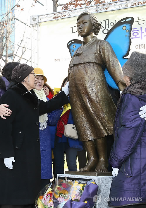 Former "comfort women," including Kim Bok-dong (left) and others, were stroking the statute of comfort women that was created by undergraduate students. (photo courtesy of Yonhap) 