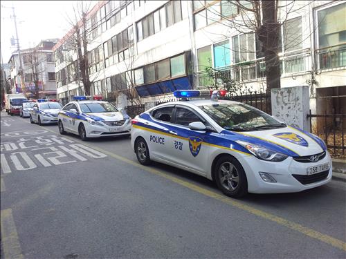 Four patrol cars made their rounds in an alley in the Gangseo district. The reason the cars patrol in line is to threaten potential burglars, and to investigate the tiniest signs of theft. (Image : Yonhap)