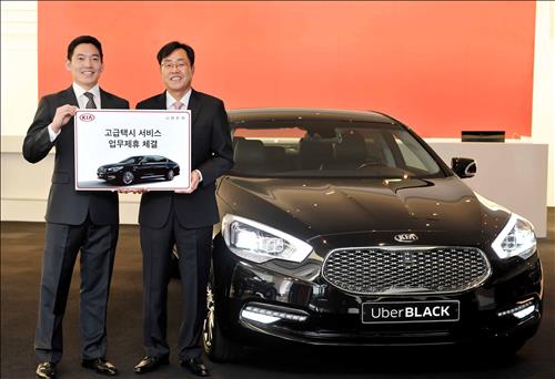 Calvin Kang (L), general manager of Uber Korea, and Cho Yong-won, head of the sales division at Kia Motors, stand by a K9 model ahead of the joint relaunch of UberBlack in Seoul on Nov. 11, 2015. (Image : Uber Korea)
