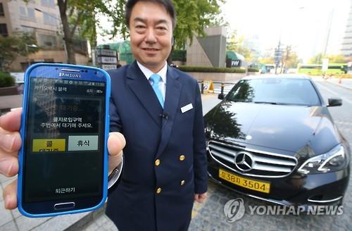 A taxi driver poses with a Mercedes-Benz taxi that can be contacted by customers via KakaoTaxi Black, which was launched in Seoul on Nov. 3, 2015. (Image : Yonhap)