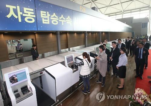 Passengers at Incheon International Airport, South Korea's main gateway, west of Seoul, try the new self check-in system that opened on Nov. 3, 2015. The system allows departing passengers to check their baggage, choose their seats and get boarding passes without the help of airline staff. (Image : Yonhap)