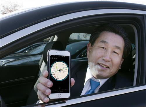 A premium taxi driver poses with a smartphone displaying the Uber application in this photo released by Uber on Jan. 19, 2016. (Image : Uber Technologies Inc.)