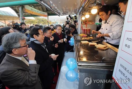 Park Young-ho, a North Korean defector, sells toast from his food truck that opened for business on Jan. 15, 2016, near a horse racing track in Gwacheon, just south of Seoul. Park is one of two North Korean defectors whose proposals were selected for operating a food truck business. Government statistics show some 26,500 North Koreans have settled in the South after escaping from their home country. (Image : Yonhap)