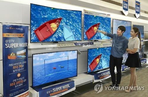 Customers shop for Ultra HD TVs displayed at a showroom in Seoul (Image : Yonhap)