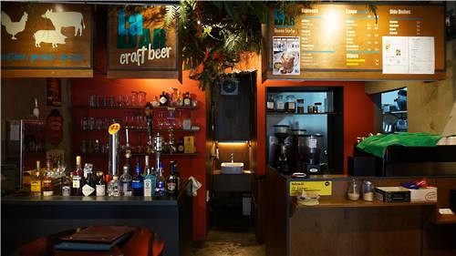 This photo shows a cafe in central Seoul that has two separate tables set up on the right and left each for coffee and beer as it is being shared by two different business owners. (Image : Yonhap)
