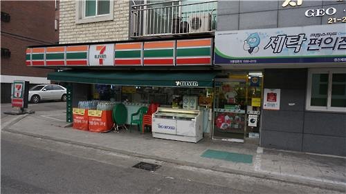 A convenience store located in western Seoul shares space with a dry cleaning shop. (Image : Yonhap)