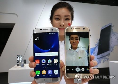 A model poses for a photo with Galaxy S7 smartphones (Image : Yonhap)
