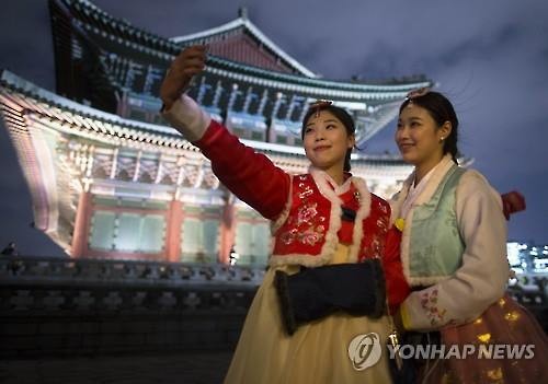 Visitors pose for selfies at Gyeongbok Palace in Seoul on March 2, 2016. (Image : Yonhap)