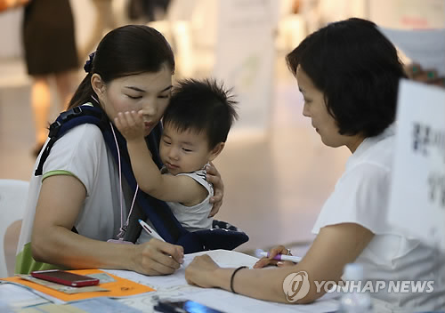 A foreign bride fills in an application at a job fair. (Image : Yonhap)