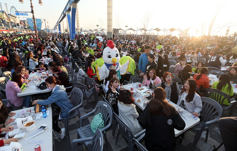 Some 4,500 employees of Chinese cosmetics and health supplement maker Aolan International Beauty Group, who are on a group tour to South Korea, enjoy fried chicken and beer, locally called "chimaek", at a massive outdoor party in the western port city of Incheon on March 28, 2016. (Yonhap)