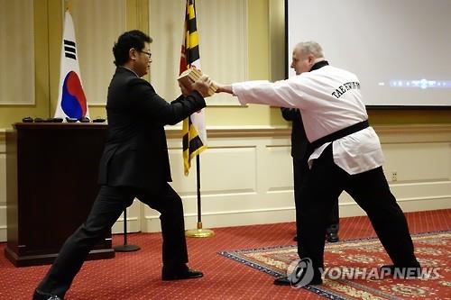 Maryland Gov. Larry Hogan attempts to break wooden boards during a ceremony held at the Maryland Miller Senate Office Building to declare "Taekwondo Day" on April 5. (Image : Yonhap)