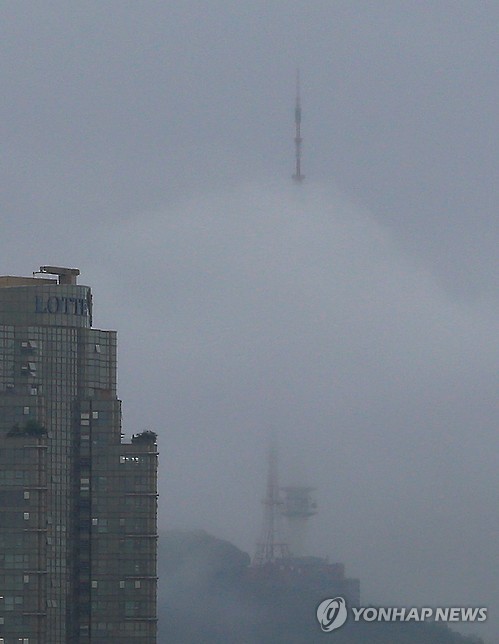 The top of N Seoul Tower is barely seen as the landmark on a hill in central Seoul is shrouded in cloud on July 4.