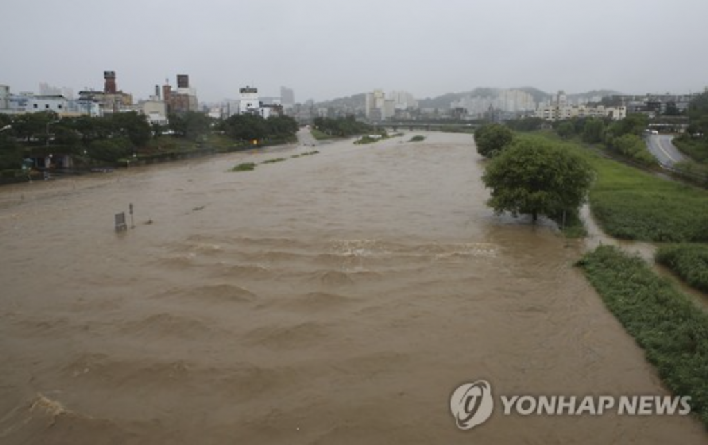 A stream cutting through the central city of Cheongju overflows its banks on July 4.