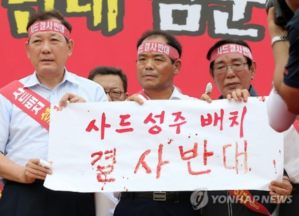 (From L to R) Kim Hang-gon, chief of the Seongju municipality, Bae Jae-man, leader of the municipality assembly, and Lee Jae-bok, a member of the municipality assembly, show a petition written in their blood during a rally in the town of Seongju on July 13 to voice objection to the deployment of an advanced U.S. missile defense system, known as Terminal High Altitude Area Defense (THAAD). (image: Yonhap)