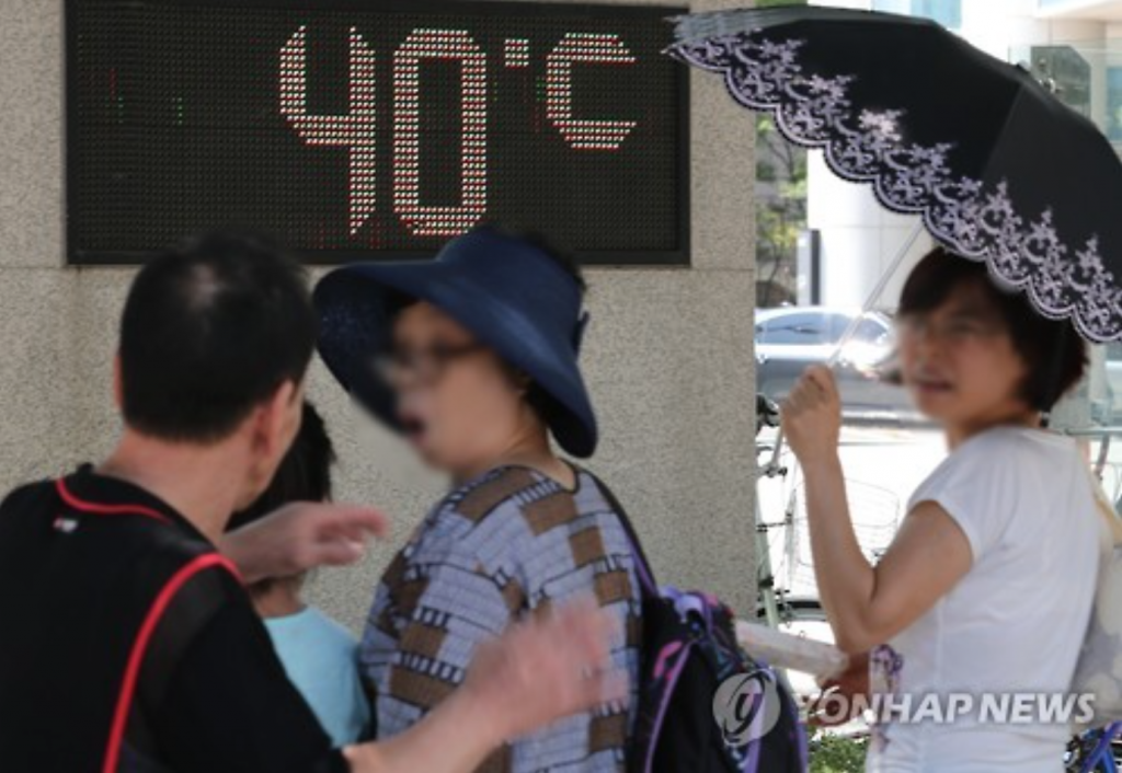 Passers-by show surprise as a thermometer set up at a Seoul park indicates the temperature is 40 C degrees on Aug. 4, 2016. A heat wave warning was issued across the nation the same day. (image: Yonhap)