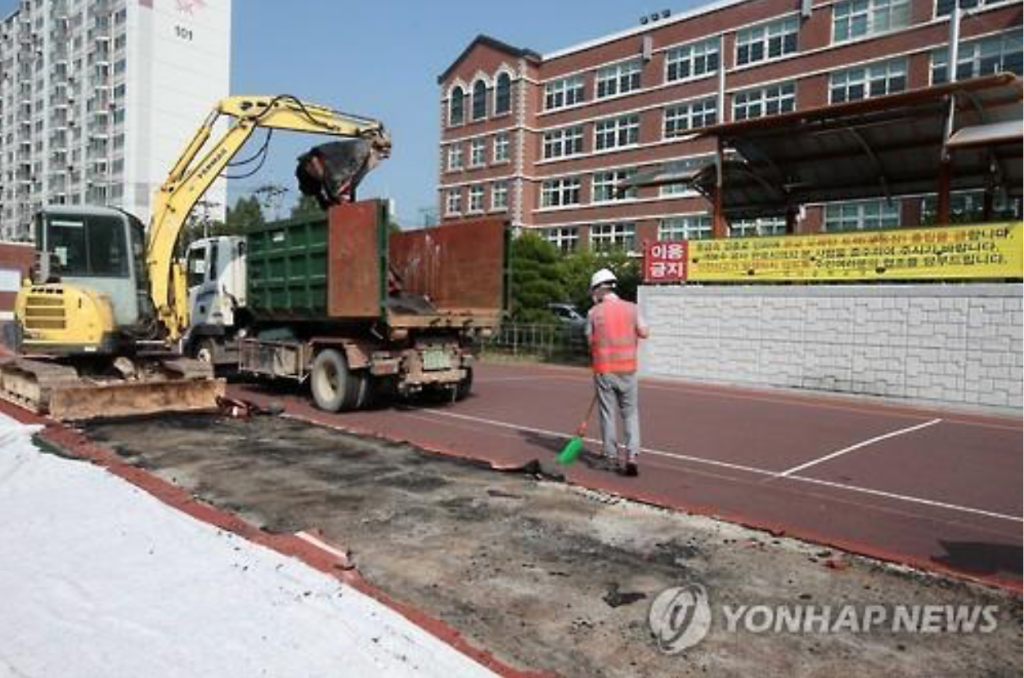 A school in Gwangju tears down its lead-contaminated urethane track. (image: Yonhap)