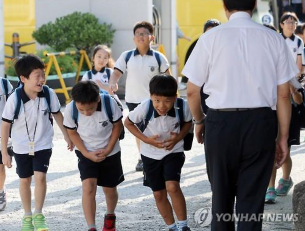 Students bow to their teacher at Shingwang Elementary School in Seoul's Yongsan Ward on Aug. 17, 2015, as they returned to school after summer vacation, which ended the previous day. (image: Yonhap)