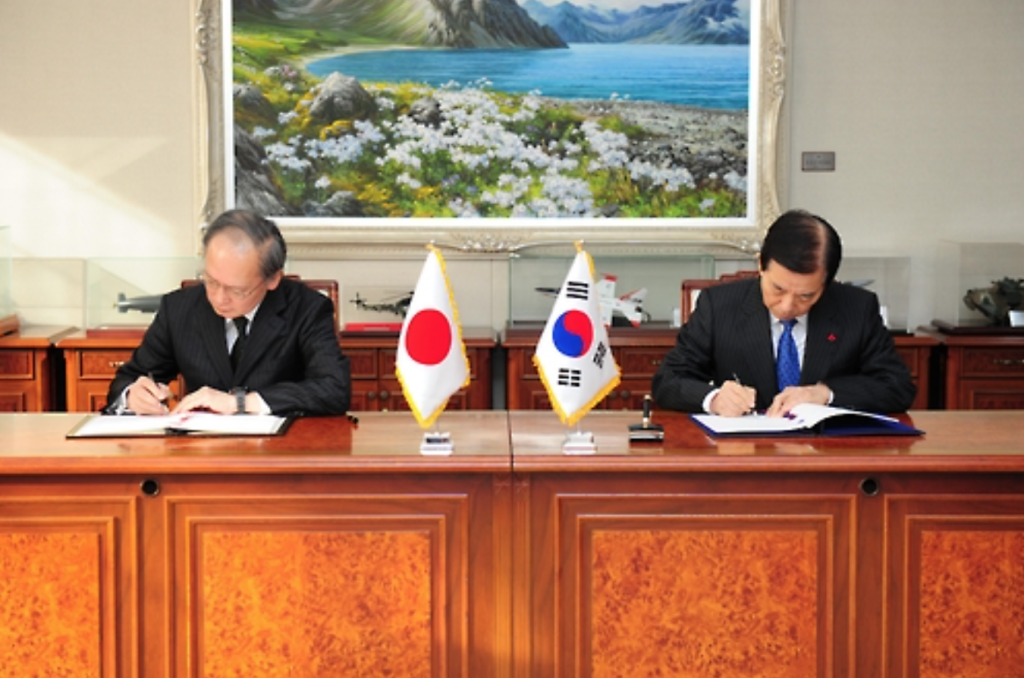 South Korea's Defense Minister Han Min-koo (R) and Japanese Ambassador to Seoul Yasumasa Nagamine sign the General Security of Military Information Agreement (GSOMIA) at the defense ministry in Seoul. (image: Yonhap)