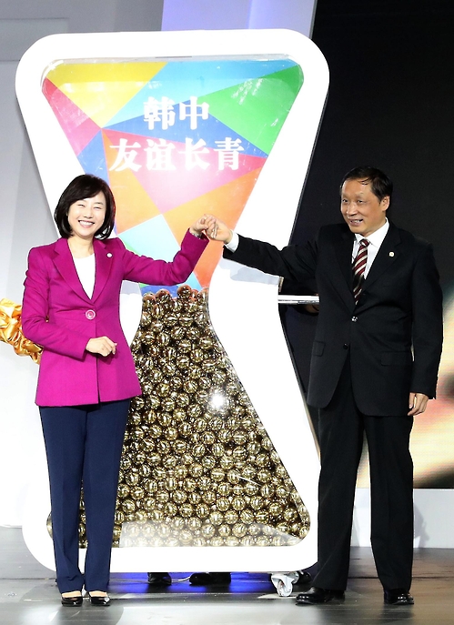 Cho Yoon-sun (L), the South Korean minister of culture, sports and tourism, and her counterpart Li Jinzao (R), chairman of the China National Tourism Administration, pose for a photo at the closing event for "Visit Korea Year" at the Kerry Hotel Beijing on Dec. 15, 2016. (image: Yonhap)