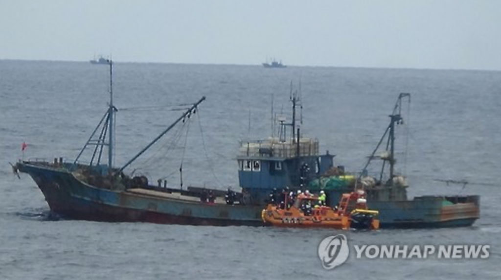 The photo, taken on Dec. 12, 2016, shows a South Korean patrol boat (in orange) approaching a Chinese boat fishing in South Korea's exclusive waters in the Yellow Sea. (image: Yonhap)