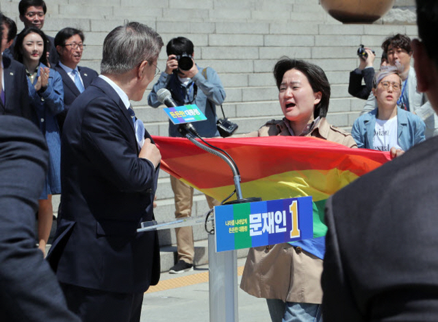Protesters hold a surprise demonstration in front of presidential front-runner Moon Jae-in at the National Assembly in Seoul on April 26 over his remarks against sexual minorities during a TV debate. (image: Yonhap)