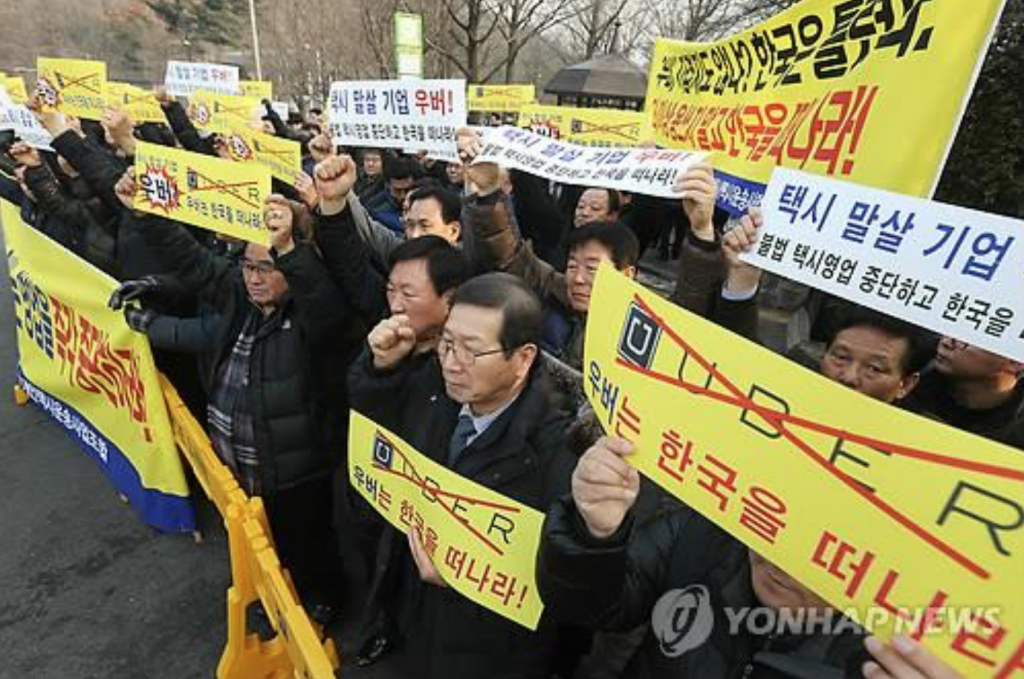 South Korean taxi drivers and taxi industry officials hold a rally in downtown Seoul on February 4, 2015, demanding that app-based taxi company Uber withdraw from the local market. (image: Yonhap)