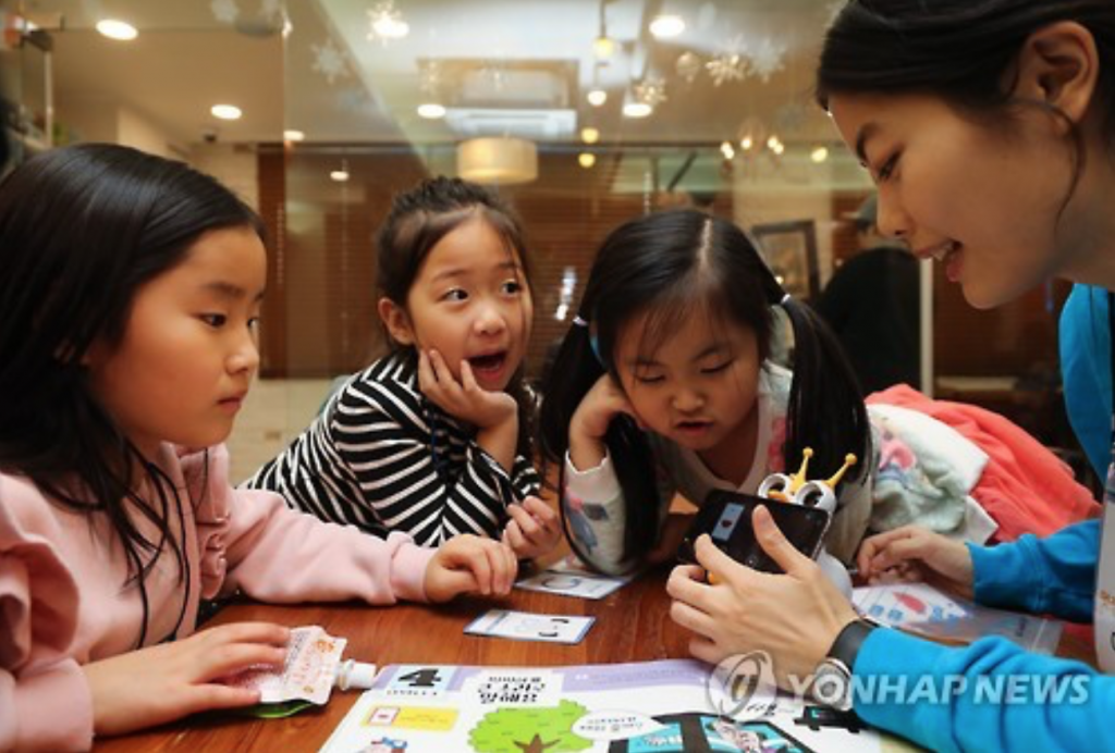 A member of the non-profit foundation Like Lion teaches kids basic coding at a kids cafe in Seoul. (image: Yonhap)