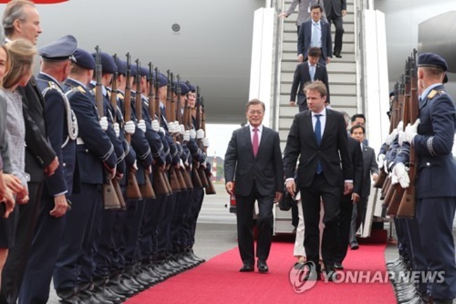 South Korean President Moon Jae-in (wearing a pink tie) walks out of his Air Force One after arriving in Berlin on July 5, 2017, on an official visit that will include a bilateral summit with German Chancellor Angela Merkel. (Image: Yonhap)