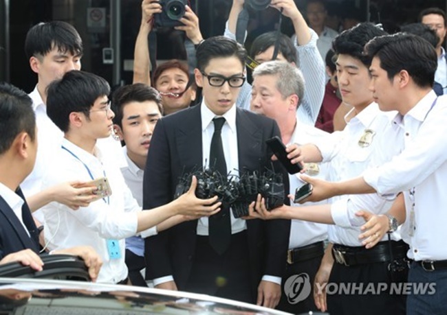 Choi Seung-hyun, aka T.O.P of popular boyband BIGBANG, leaves the courthouse surrounded by reporters after he received a suspended sentence for smoking marijuana on July 20, 2017. (Image: Yonhap)