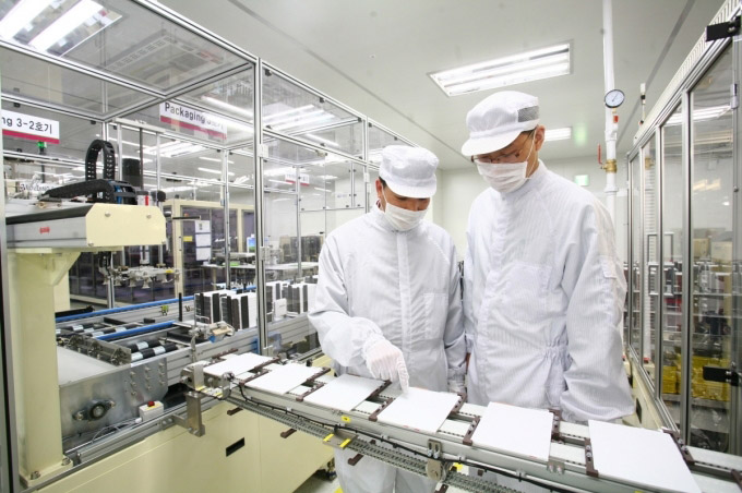 This undated photo provided by LG Chem Ltd. shows the company's researchers inspecting a lithium-ion battery.
