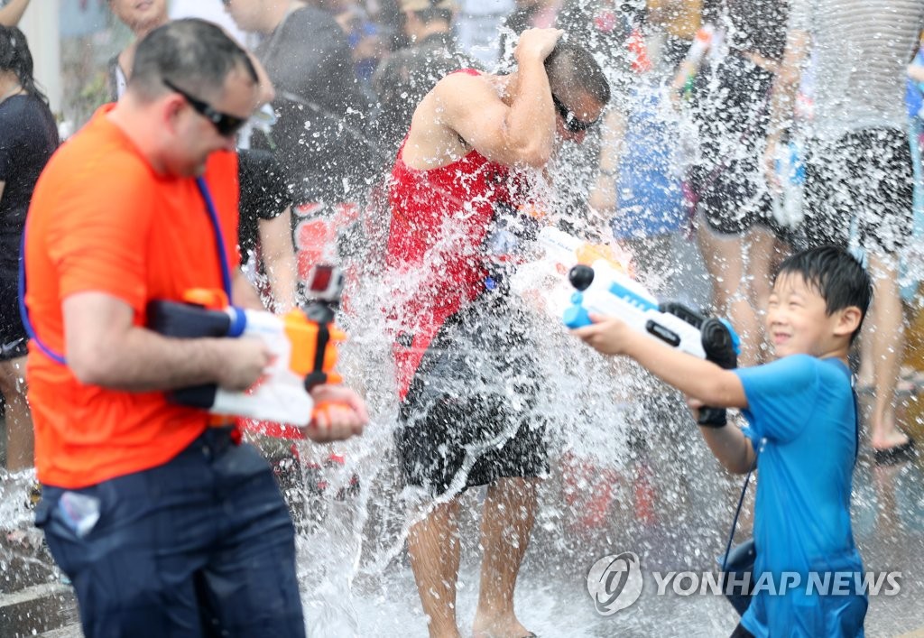 Thousands of people gathered in the heart of the South Korean capital to take part in a water gun fight in the sweltering summer heat over the weekend. (Image: Yonhap)
