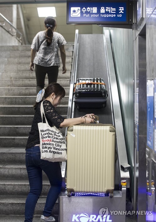 The plight of travelers lugging 20 to 30 kilograms suitcases up and down the stairs of Seoul Station apparently caught the Korea Railroad Corporation's notice, as it announced that conveyor belts had been installed along the stairways leading to and from the subway and the railroad. (Image: Yonhap)