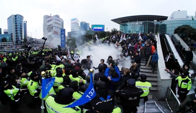 Chanting slogans such as "Kim Jong-un's Pyongyang Olympics", a right-leaning activist group held a rally in the public square in front of Seoul Station, where its members burned the North Korean flag and a picture of Kim Jong-un. (Image: Yonhap)