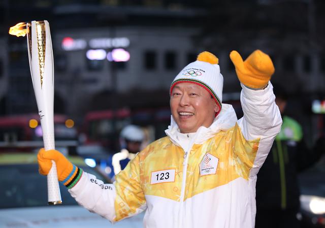 Shin Dong-bin, the head of South Korean retail giant Lotte, carries a torch for the 2018 PyeongChang Winter Olympics in Seoul on Jan. 14, 2018, as part of a nationwide 2,018-kilometer relay. (image: Yonhap) 