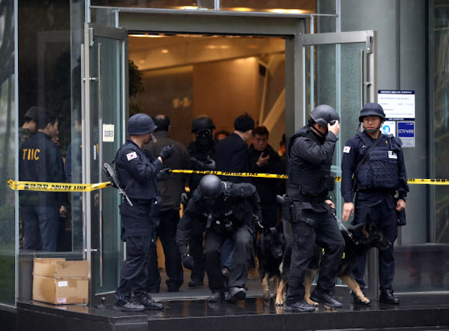 Police coming out of Samsung Life Insurance's corporate building after someone called in a bomb threat. (Image: Yonhap)