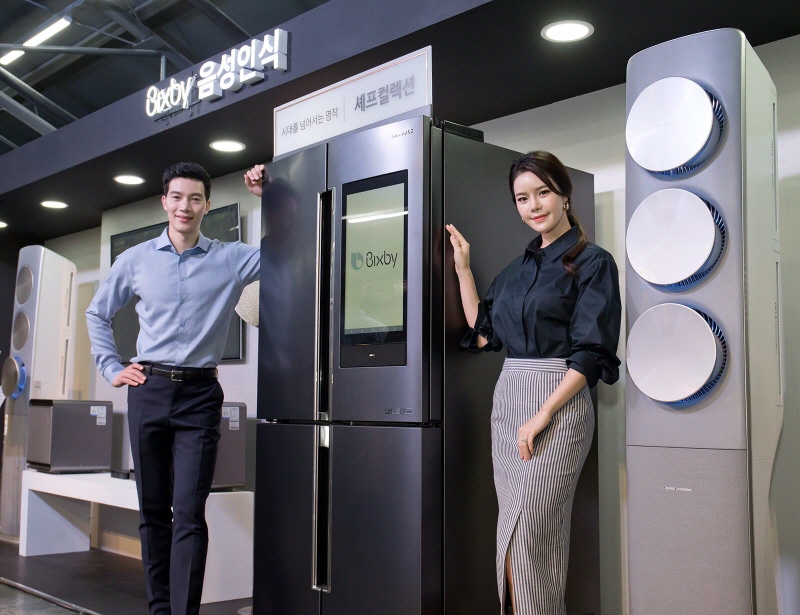 Models pose with a Samsung Electronics Co.'s refrigerator equipped with the voice-recognition system Bixby during a press conference in Seoul on May 17, 2018. (image: Samsung Electronics)