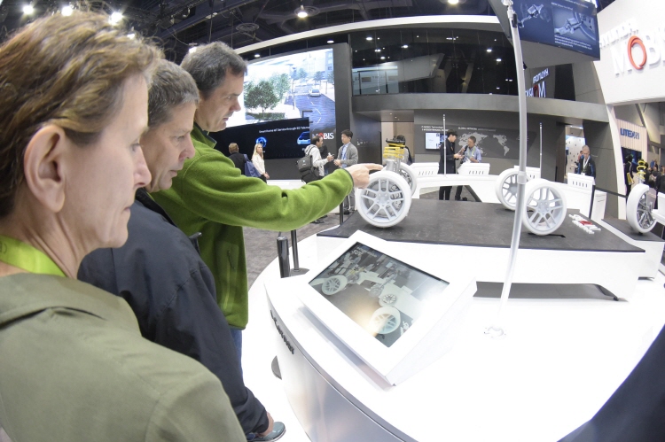 In this photo taken at the Consumer Electronics Show in Las Vegas in January, officials from a carmaker look around next-generation car technologies displayed at Hyundai Mobis' booth. (image: Yonhap)