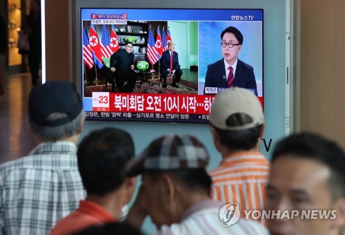 People watch TV news on the summit talks between U.S. President Donald Trump and North Korean leader Kim Jong-un at Seoul Station in Seoul on June 12, 2018. (Yonhap)