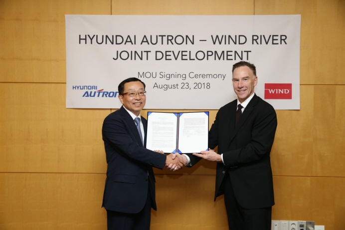 Hyundai-AUTRON CEO Cho Sung-hwan (L) shakes hands with Wind River CEO Jim Douglas after signing an initial pact on a business partnership in developing autonomous driving technologies and connectivity control platforms in Seoul on Aug. 23, 2018. (image: Hyundai-AUTRON)