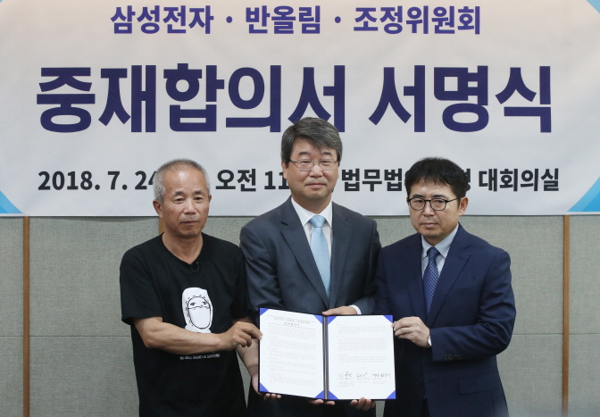 Hwang Sang-ki (L), who represents the Supporters for the Health and Rights of People in the Semiconductor Industry; Kim Ji-hyung (C), who heads the mediation committee; and Samsung Electronics Co. executive Kim Sun-shik pose for a photo after signing an agreement on accepting upcoming mediation in Seoul on July 24, 2018. (image: Yonhap)