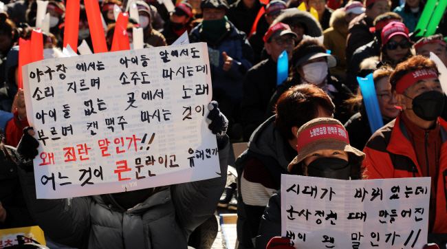 Noraebang owners carried signs that said “amend law criminalizing owners for selling canned beer to adult customers,” or “singing and drinking beer is what the people want.” (image: Yonhap)