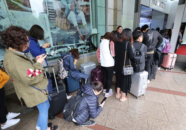 This file photo shows Chinese shoppers waiting in line to buy goods at a local duty free store in Seoul. (Yonhap)