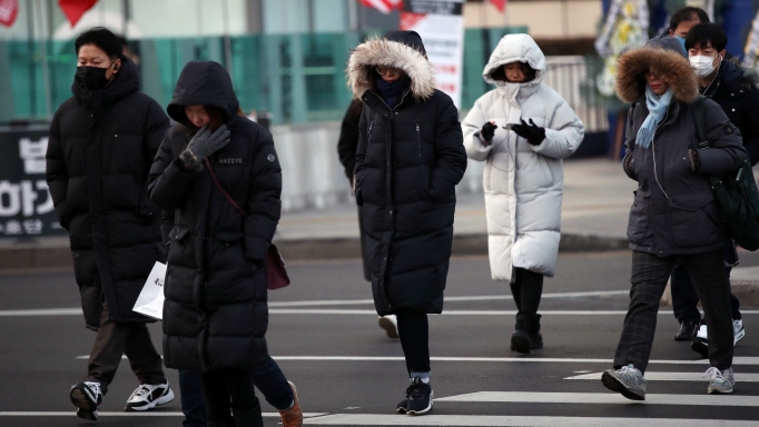 Citizens in thick winter jackets walk on streets near Gwanghwamun Square in central Seoul on Dec. 28, 2018. (Yonhap)
