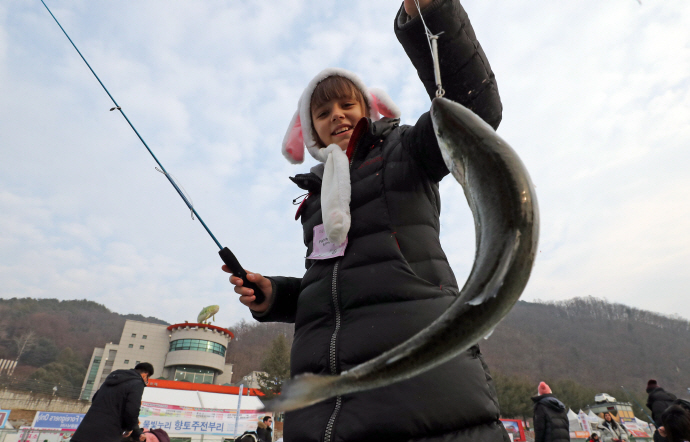 A foreign tourist fishing for trout. (Yonhap)