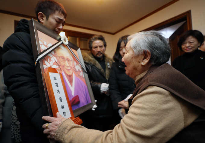 Gil Won-ok, a surviving wartime sexual slavery victim, looks at the portrait of her late friend, Kim Bok-dong, at a shelter run by a group advocating the victims in Seoul's western district of Mapo on Feb. 1, 2019. (Yonhap)