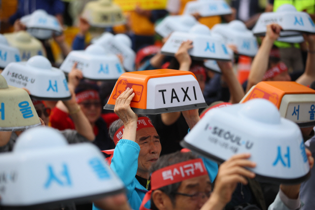 Taxi drivers hold a rally to protest against new ride service providers such as the van-hailing service Tada in front of the transport ministry in Sejong Special Self-governing City on June 19, 2019. (Yonhap)