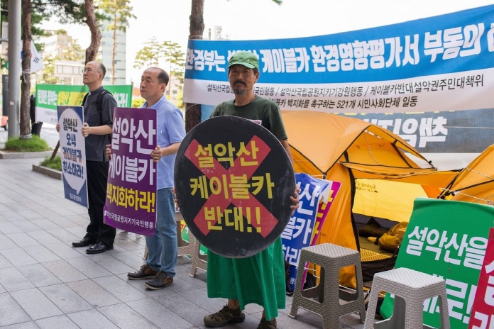 Environmental activist Park Grimm leads a sit-in protest across from Seoul Station on Aug. 14, 2019, to demand the cancellation of the planned Mount Seorak cable car. (Yonhap)