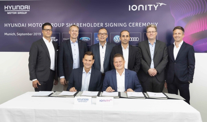 Thomas Schemera (front row, L), Executive Vice President at Hyundai Motor Group, and IONITY CEO Michael Hajesch (front row, R) pose for a photo with officials from BMW, Ford, Mercedes-Benz and Porsche after signing a strategic partnership agreement at IONITY's headquarters in Munich, Germany, on Sept. 6, 2019. (image: Hyundai Motor Group)