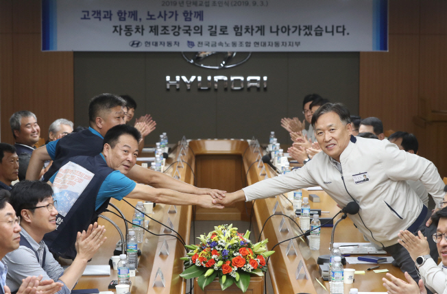 Representatives from Hyundai Motor Co.'s management and labor union shake hands after signing a collective bargaining agreement at the company's plant in Ulsan on Sept. 3, 2019. (Yonhap)